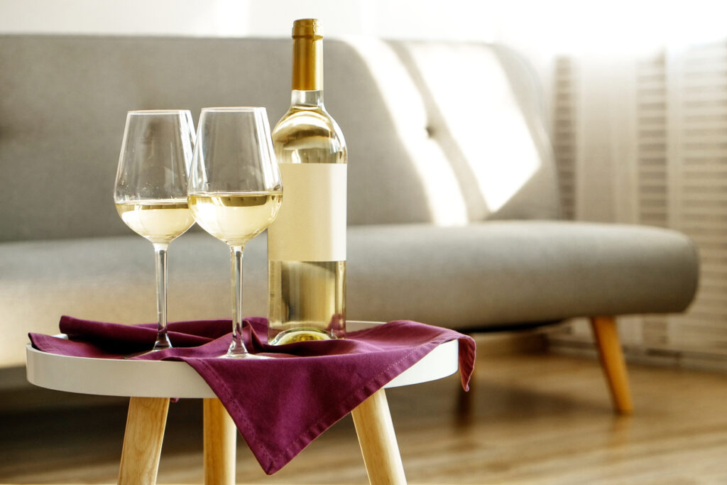 テーブルの上に白ワインのボトルとグラスが乗っている
