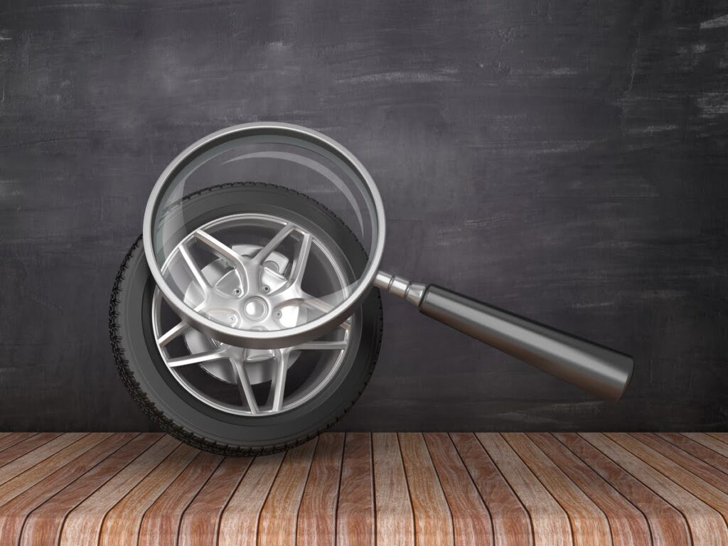 Magnifying Glass with Car Wheel on Chalkboard Background - 3D Rendering